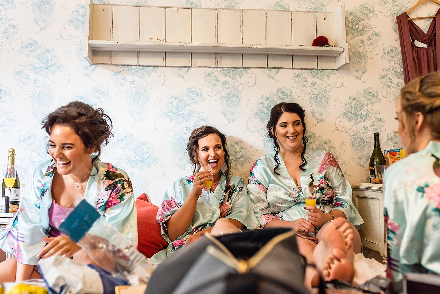 Bridesmaids in their dressing gown toasting during wedding preparation