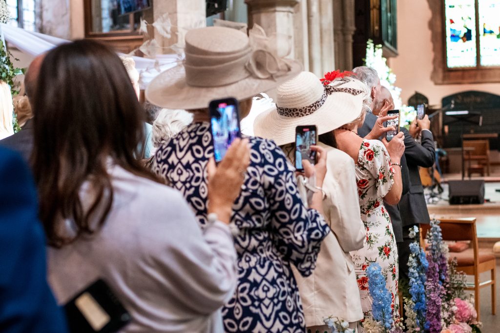 Guests photographing th couple with their phone from Bromley wedding photographer 