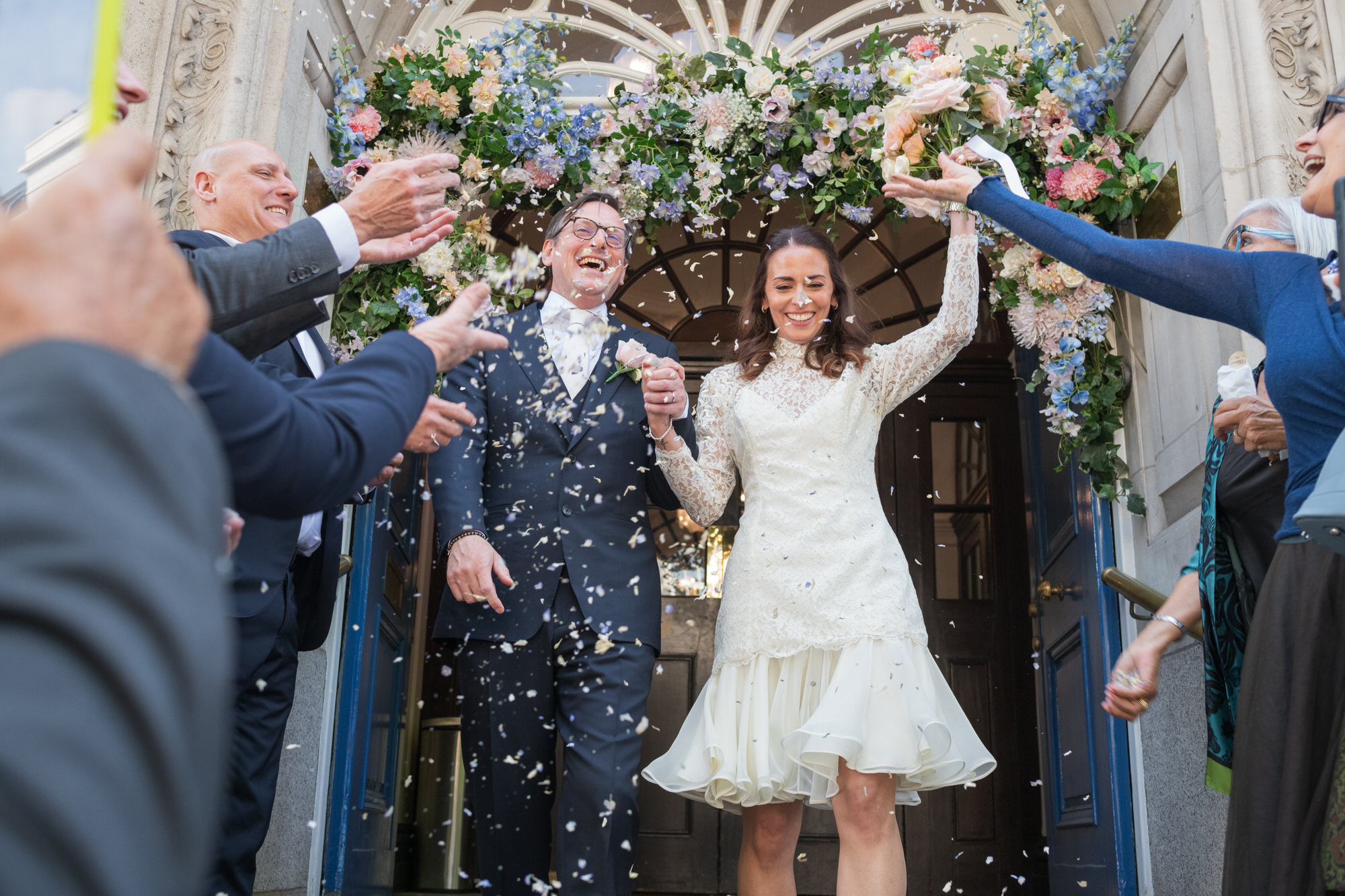 wedding couple outside Chelsea Town Hall with guests throwing confetti