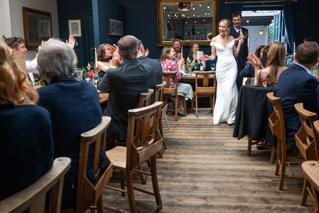 The bride and groom entering the reception room to applause at The Lordship Pub, Dulwich