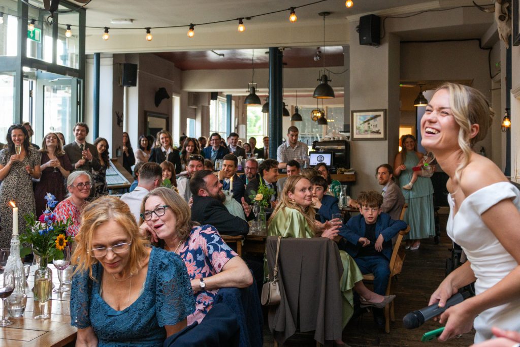 Guests clapping and cheering as the bride speaks during the reception at The Lordship Pub, Dulwich