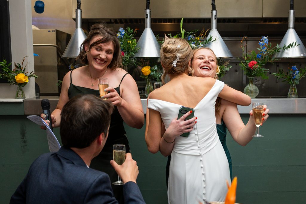 A bridesmaid hugging the bride during speeches at The Lordship Pub, Dulwich