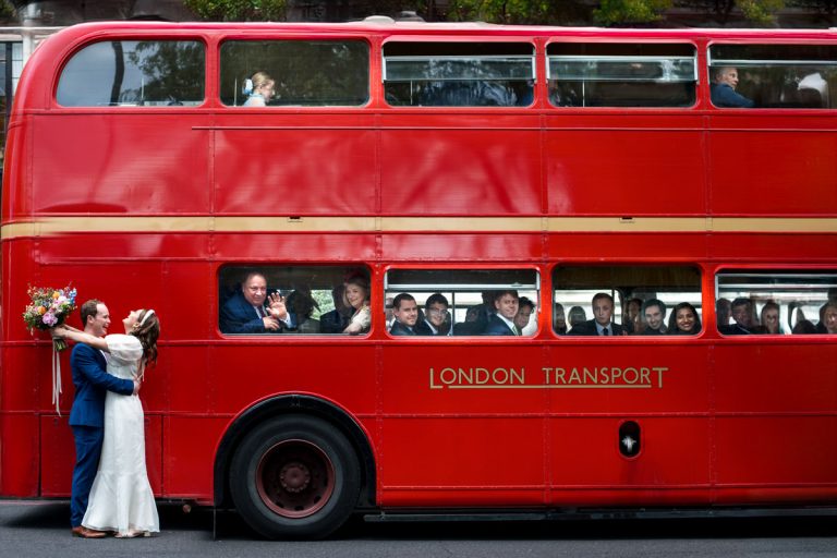 Wedding couple in front of a red bus in front of Islington Town Hall