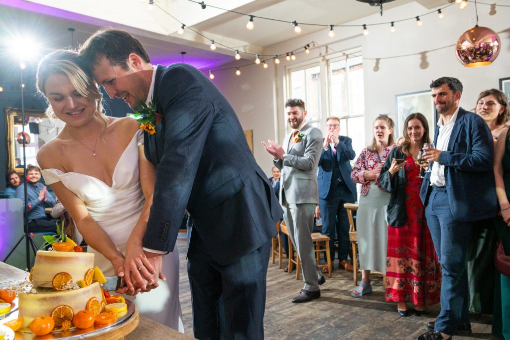 The bride and groom cutting their wedding cake together at The Lordship Pub, Dulwich